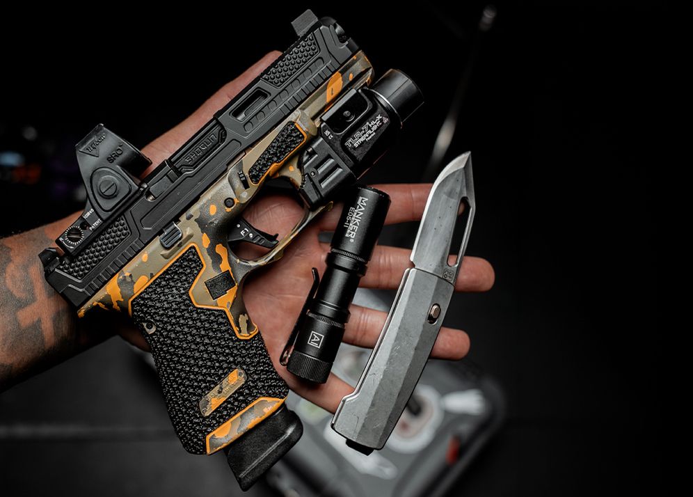 Everyday carry pistol, light and knife in hand