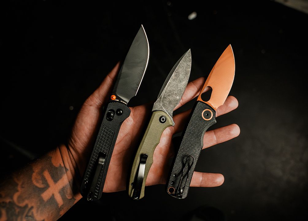 Three everyday-carry folding knives in hand