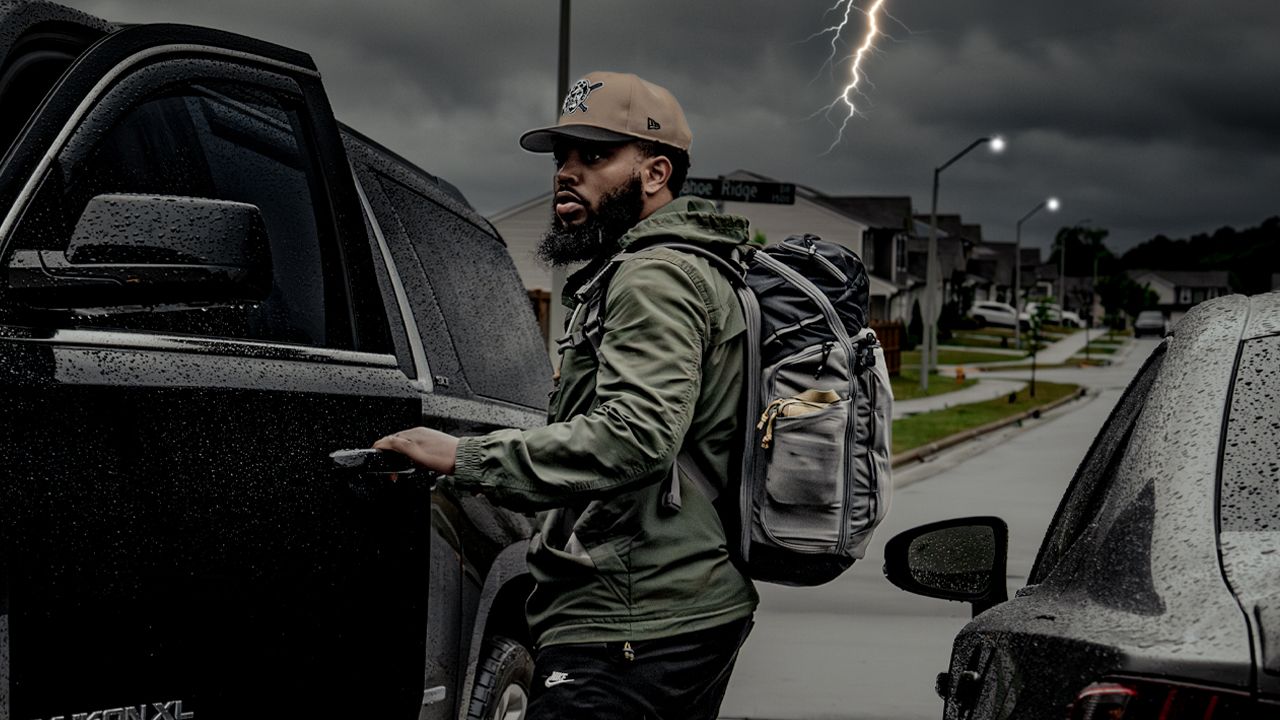Steph loading a go-bag into the truck as a storm rolls in